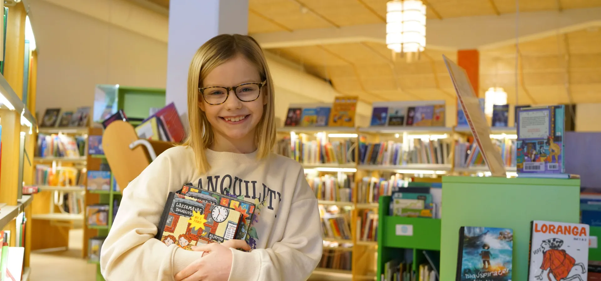 Barn som håller i böcker på biblioteket