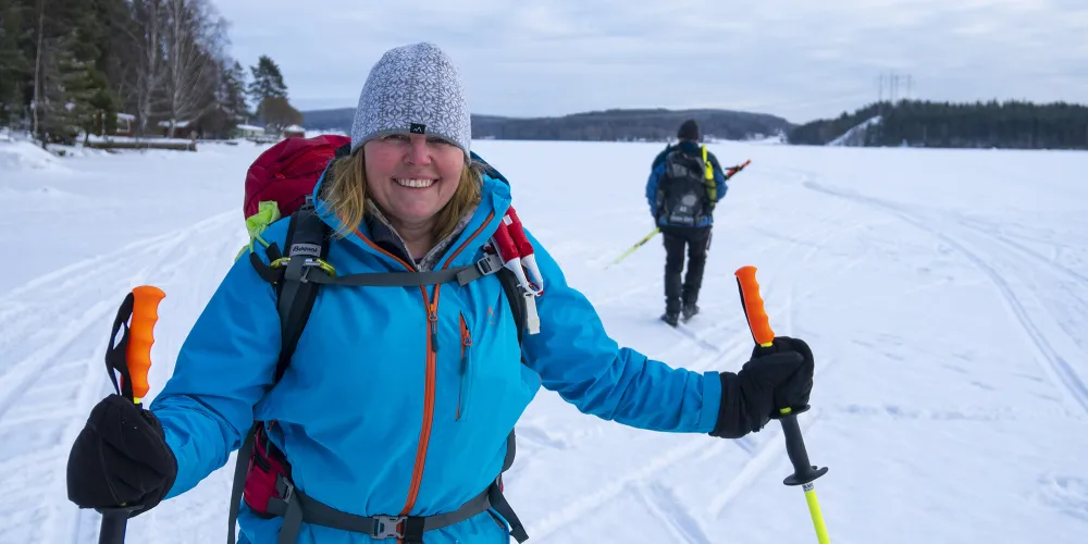 Glad kvinna ute på isen i vintrig skärgård