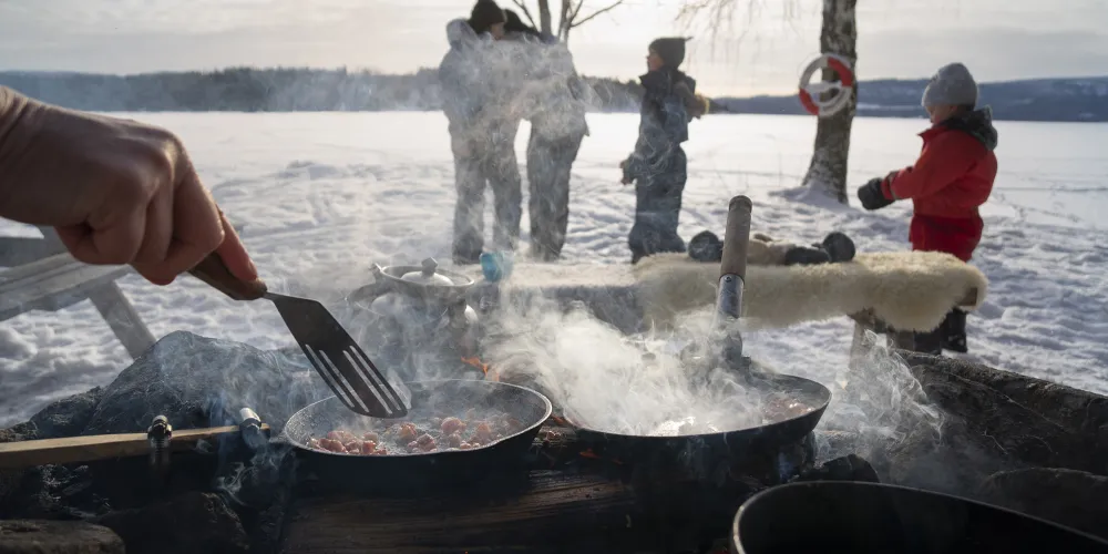 Grillning tillsammans utomhus i vinterlandskap