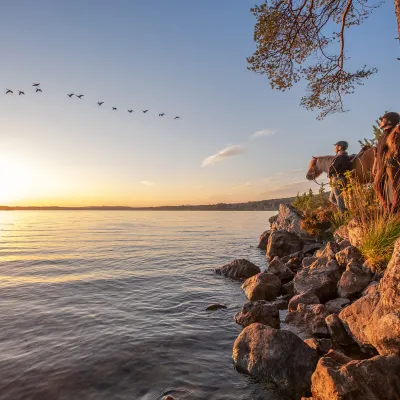 Ridtur på hösten med utsikt över sjö och solnedgång