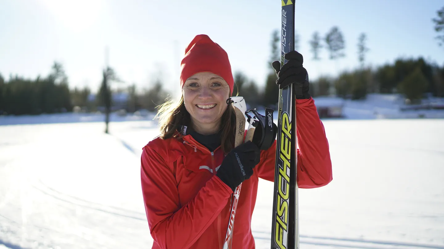 Jessica på väg att åka längdskidor en solig vinterdag